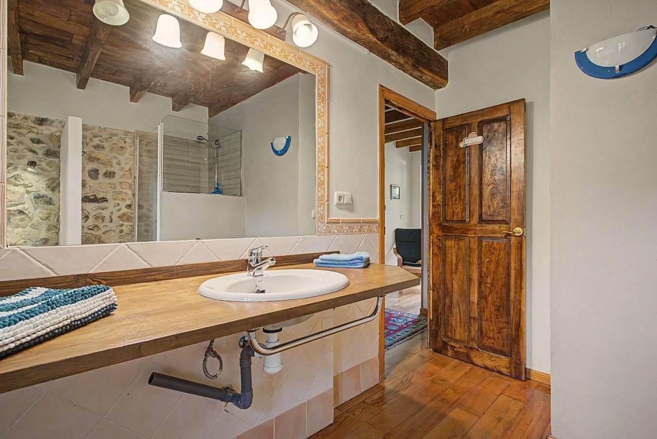 Baño con encimera de madera y espejo