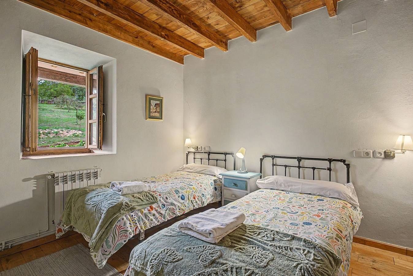 Dormitorio con dos camas y techo de madera