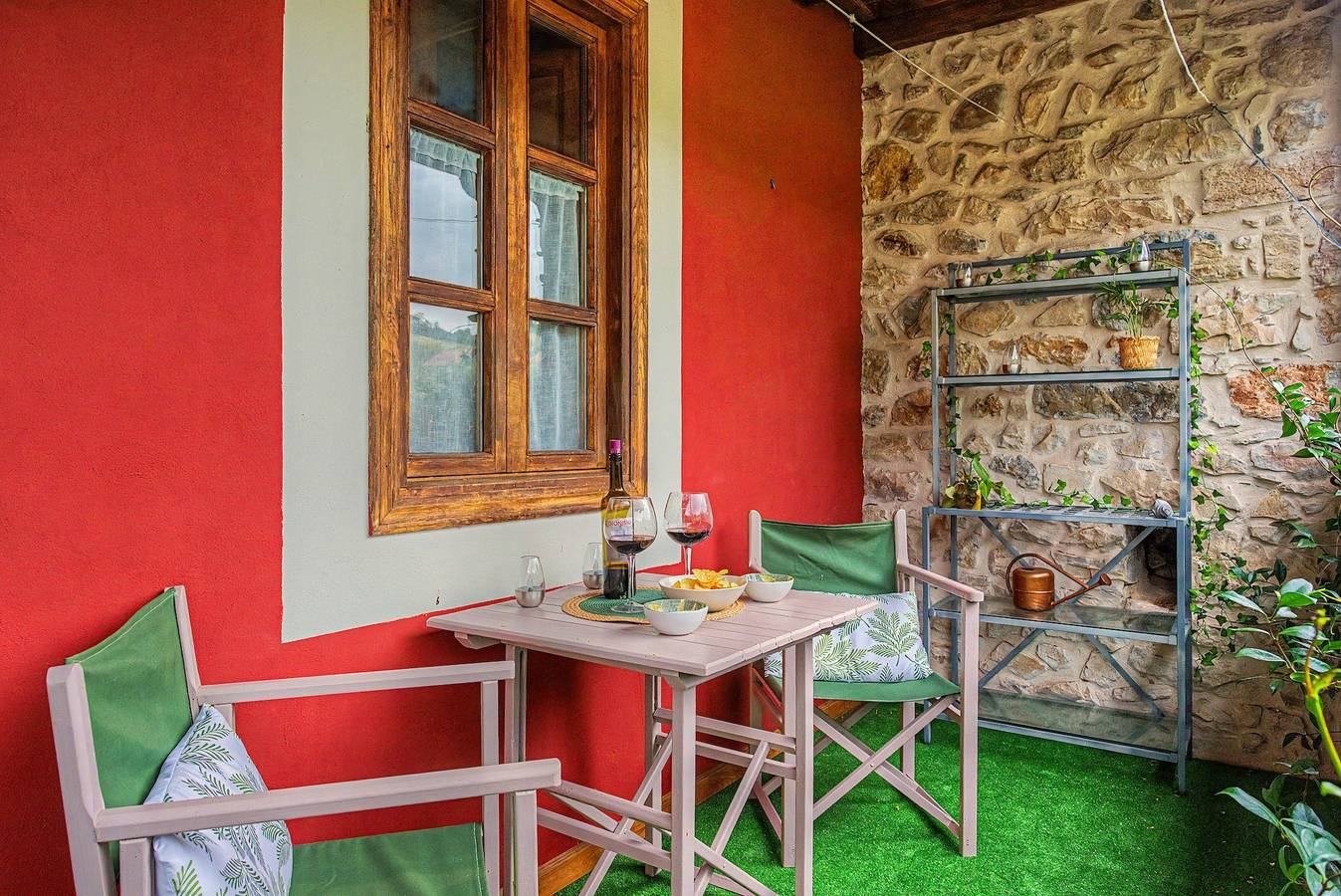 Terraza con pared roja y mesa con copas