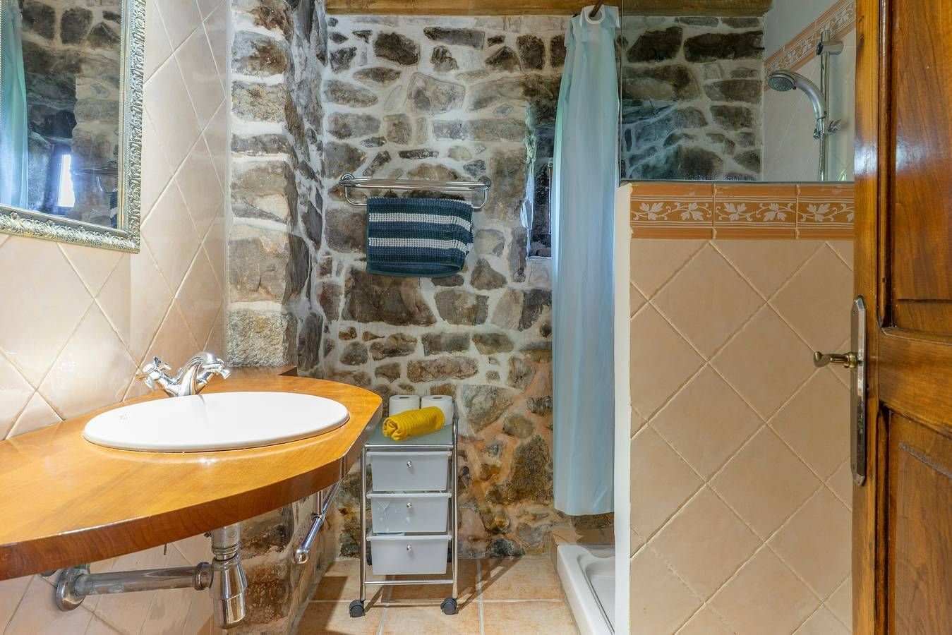 Baño con lavabo sobre encimera de madera