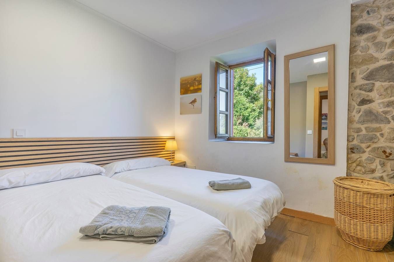 Dormitorio con dos camas y ventana al verde