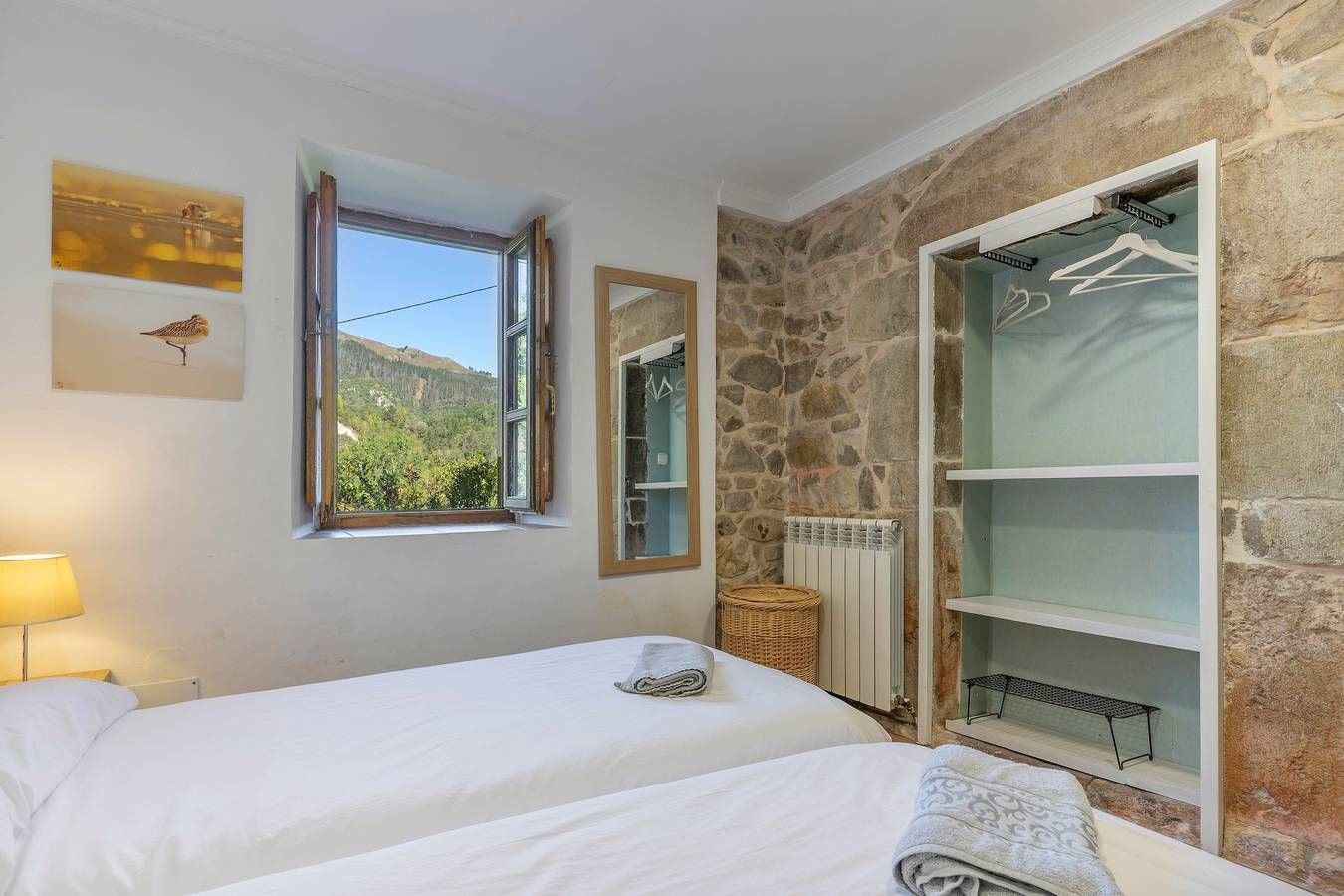 Dormitorio con dos camas y ventana a la montaña