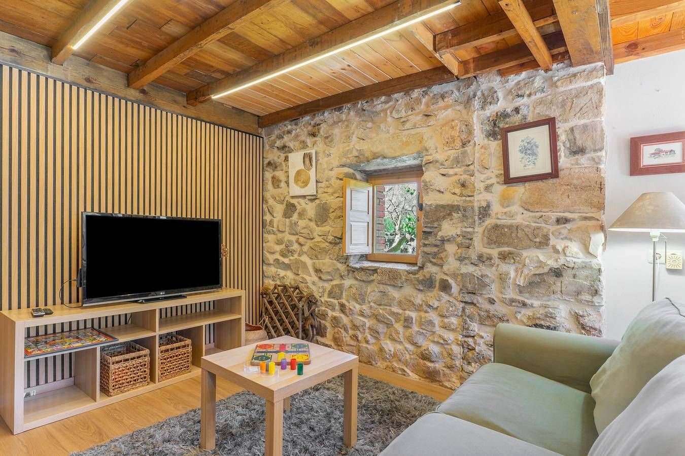 Salón de la Suite del Bosque con pared de piedra y sofá