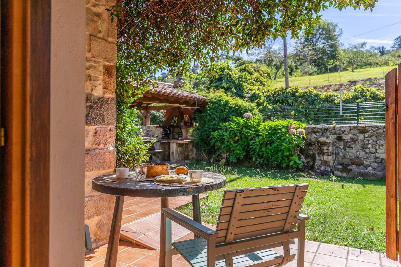 Terraza con mesa de desayuno y vista al jardín