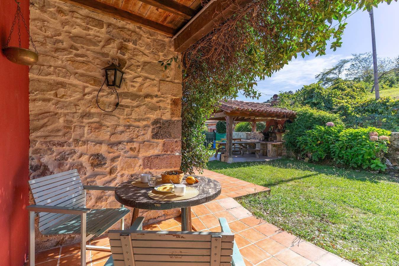 Terraza con muro de piedra, mesa y sillas